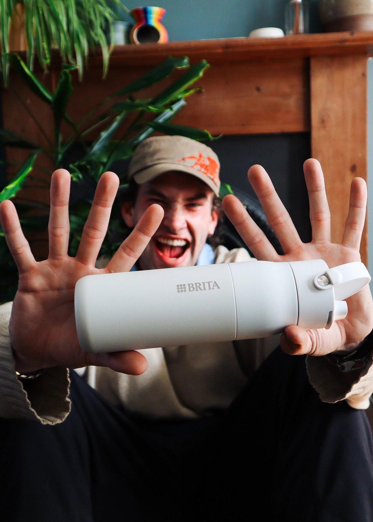 Man in a cappy, proudly showing his BRITA LARQ Filter Bottle.