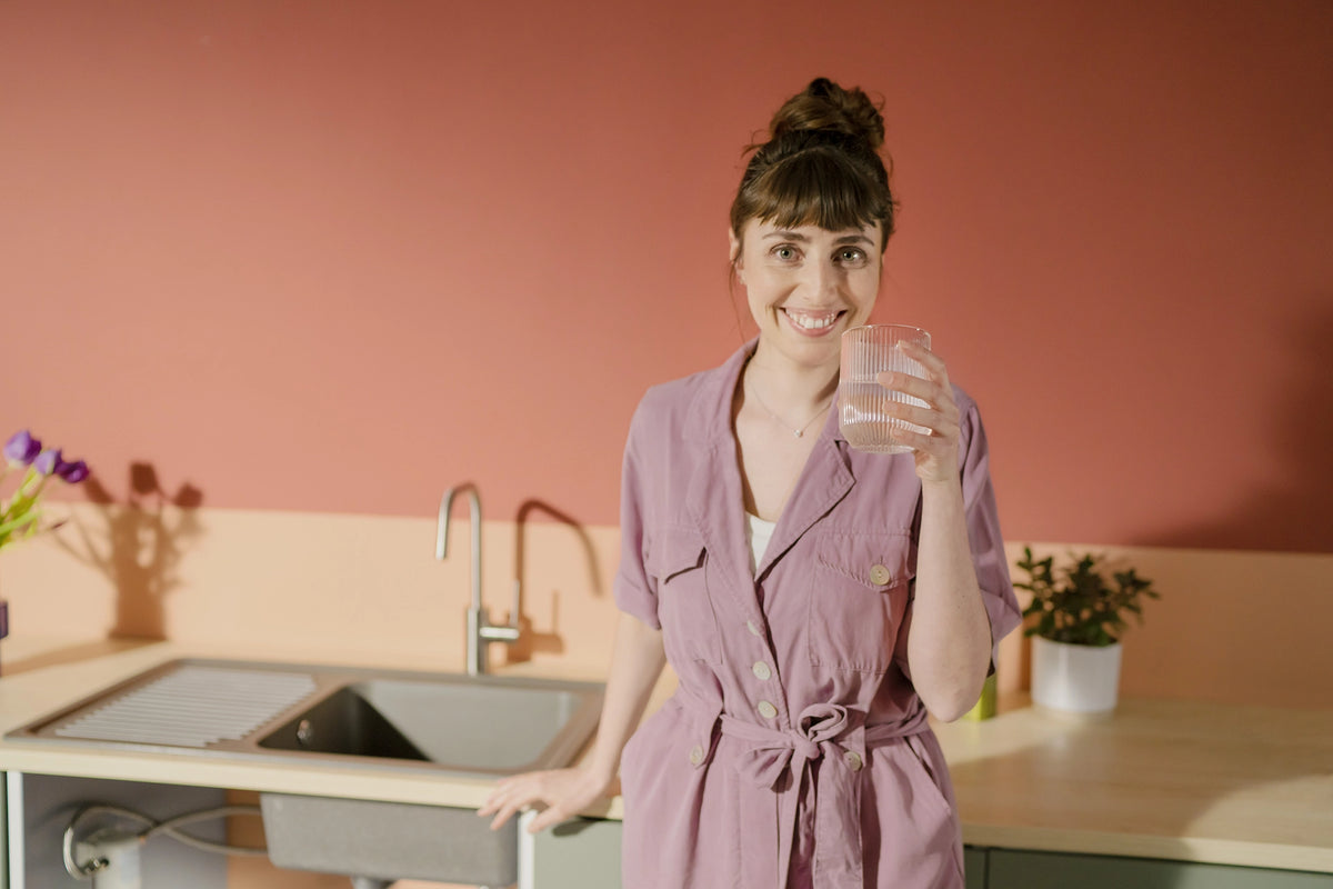 Smiling woman drinking in kitchen