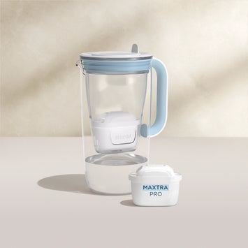 De l'eau filtre Carafe en verre en bleu sur fond beige